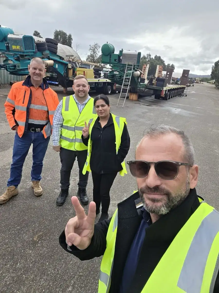 Paul Cohalan and the All Trucks Insurance team on site at an Australian trailer yard with heavy float trailers behind them