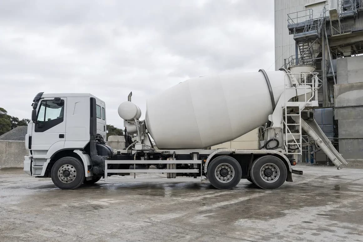 Concrete agitator truck parked side-on at an Australian batching plant, mixer drum and rear chute in view