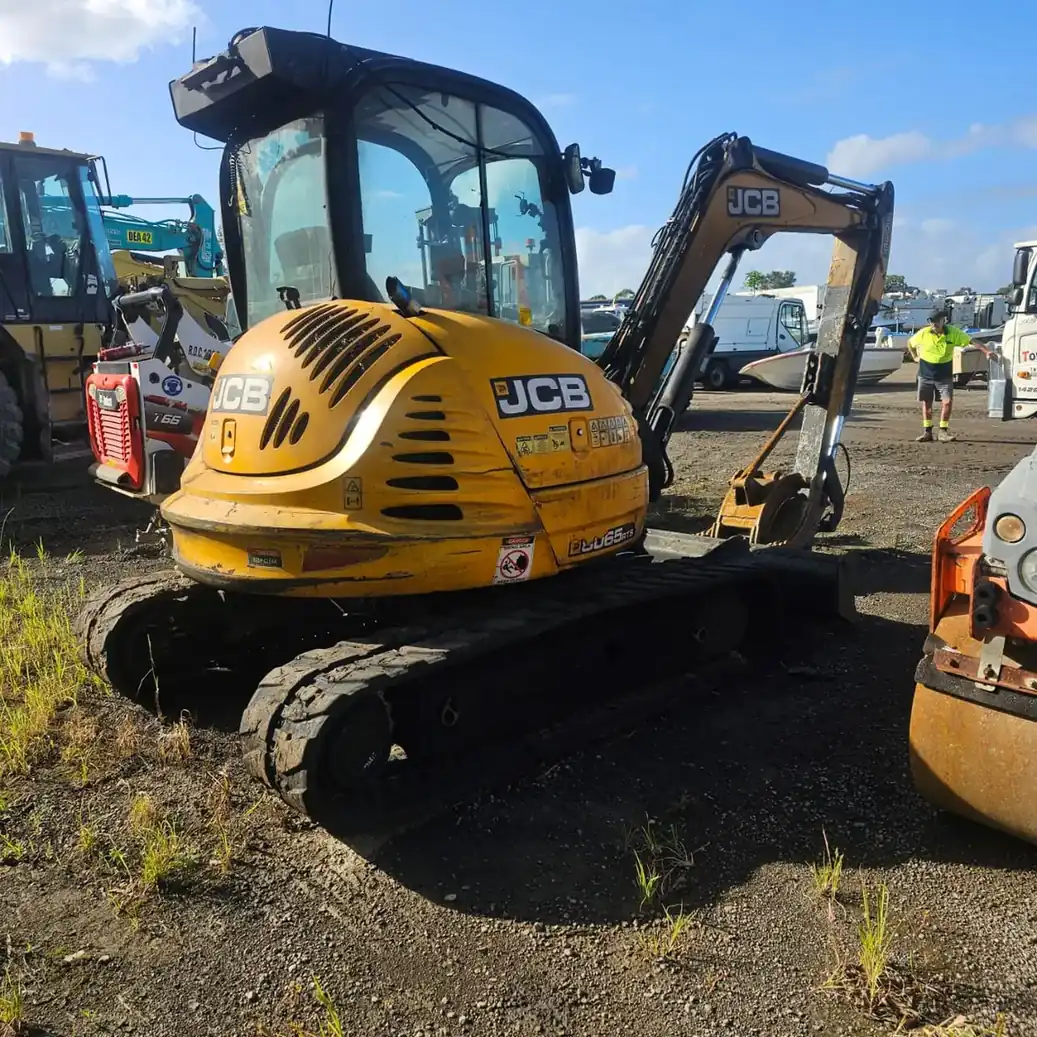 Yellow JCB tracked excavator parked at an Australian equipment yard