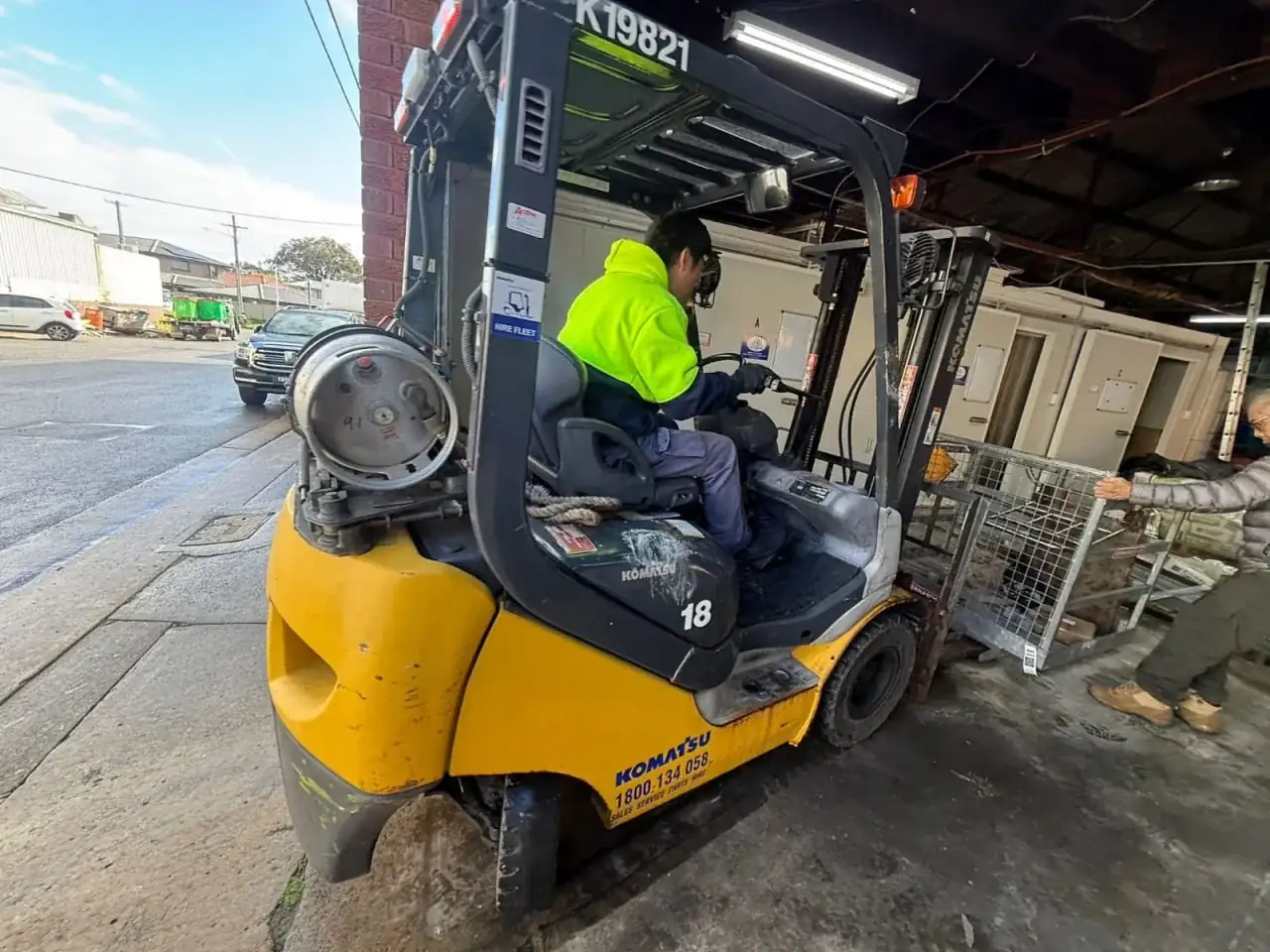 Forklift operator handling a Komatsu counterbalance forklift at an Australian loading dock