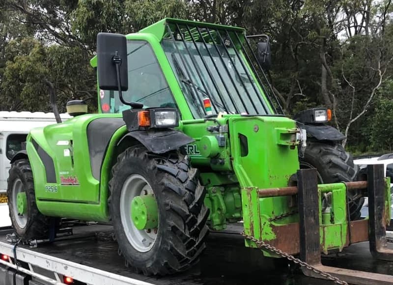 Green Merlo telehandler with its forks fitted, loaded for transport in Australia