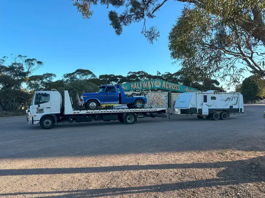 Tow truck recovering a vehicle and towing a caravan on an Australian highway