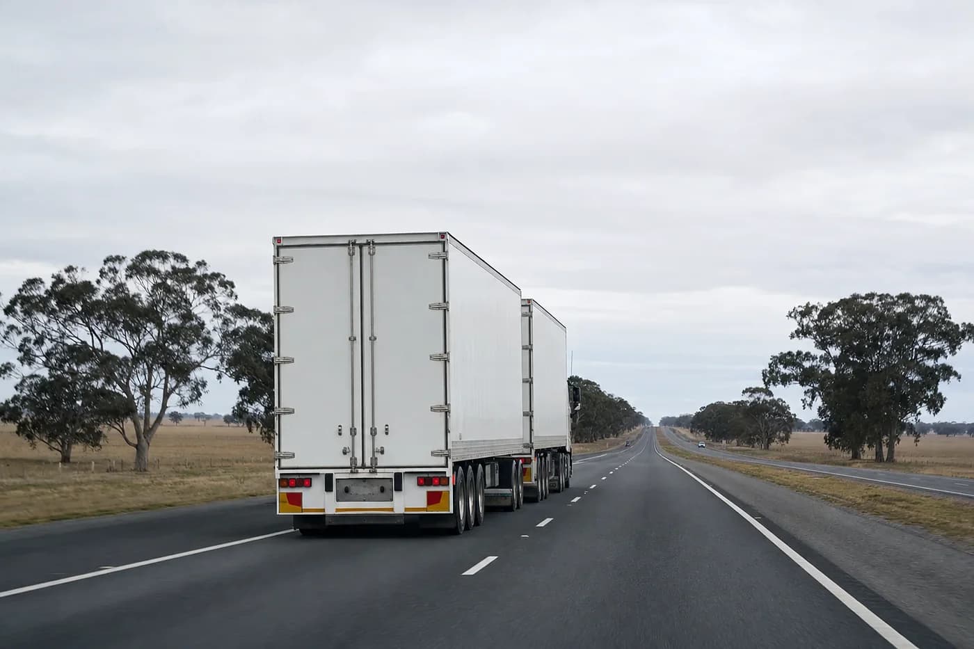 B-double keeping left on a two lane highway through the dry paddocks and gum trees of western Victoria
