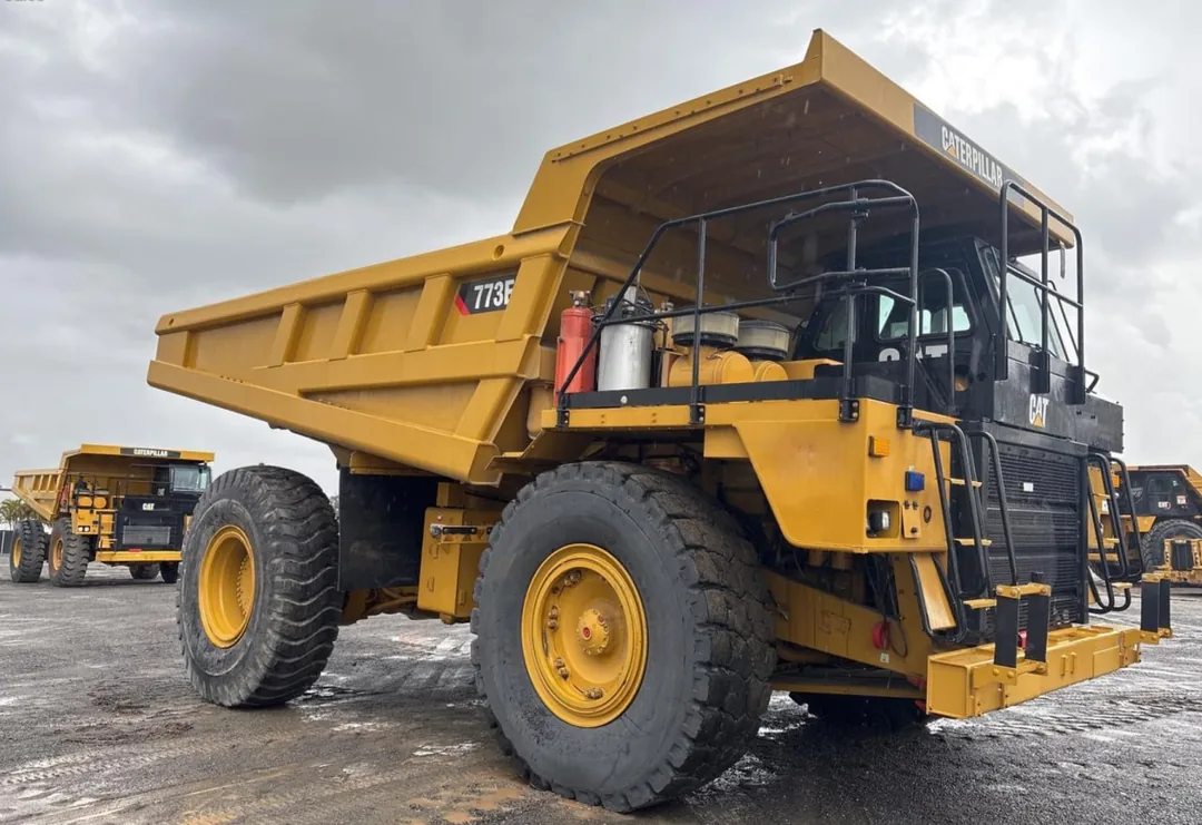Caterpillar 773E rigid off-road haul truck parked on a wet hardstand in Australia
