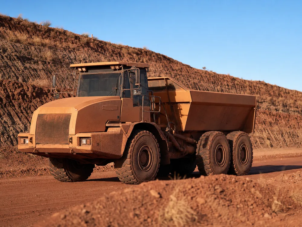 Articulated off-road dump truck on an unsealed haul road at an Australian open-cut site