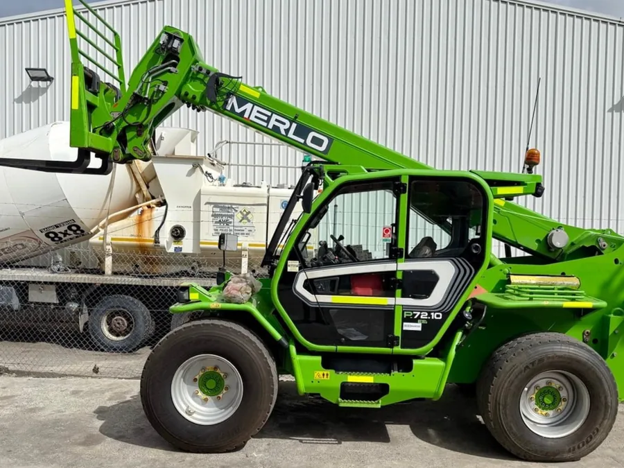 Green Merlo P72.10 telehandler with the boom raised, parked at an Australian yard