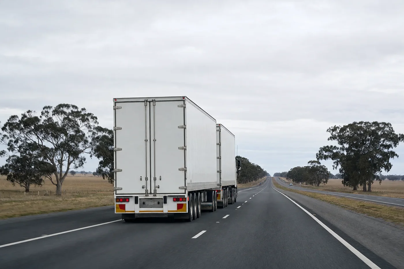 B-double keeping left on a two lane highway through the dry paddocks and gum trees of western Victoria